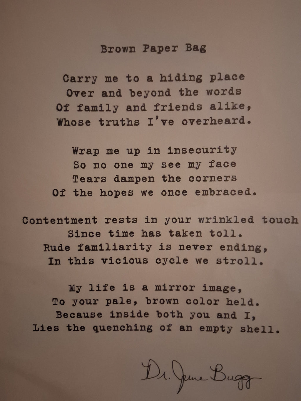 A printed poem titled 'Brown Paper Bag' on aged beige paper, with black typewriter-style text and a handwritten signature at the bottom. The author of this poem is, Eddie Wyatt, Jr. The signature is his alias name 'Dr. JuneBugg.'