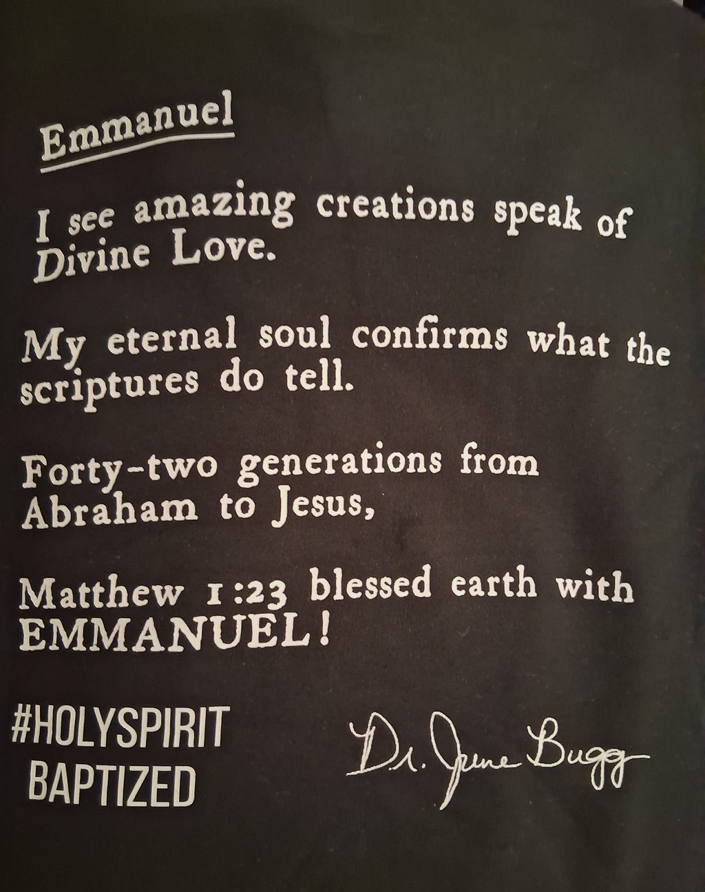 A close-up of a black garment, featuring a white printed typewriter-style quote from Matthew 1:23 starting with 'Emmanuel' and signed 'Dr. JuneBugg' which is the alias of author Eddie Wyatt Jr.