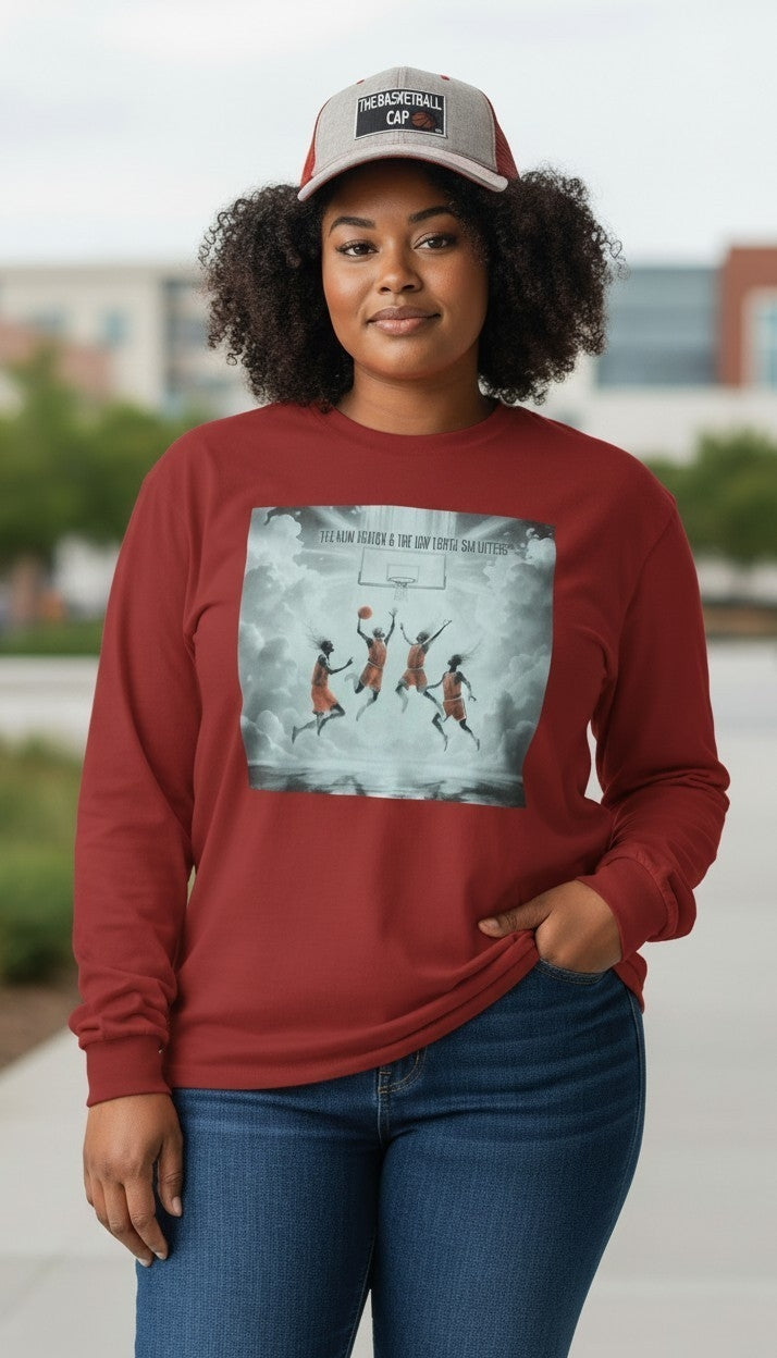 A woman wearing a rust-red long-sleeve crewneck sweatshirt with a basketball-themed graphic print on the front, paired with blue jeans and a gray and red trucker hat. Photo prompted by Eddie Wyatt Jr. 